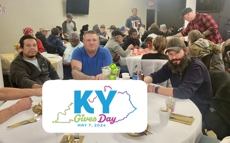 KY Gives Day May 7, 2024 logo over photo of men sitting at dining table and smiling while volunteers pour drinks in the background